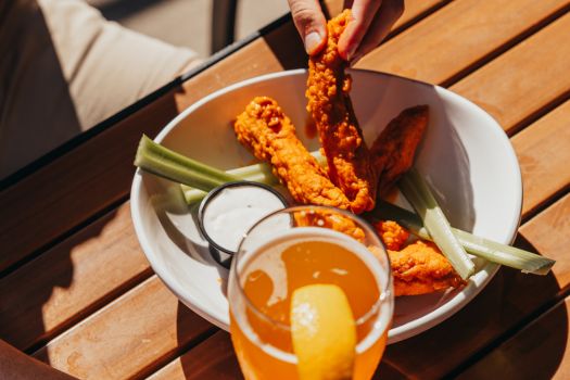 famous zingers on a plate with celery and a beer